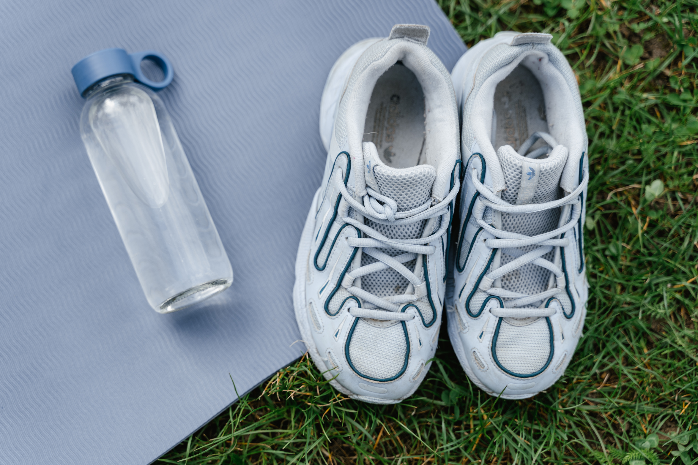 White and Blue Running Shoes on Gray Yoga Mat